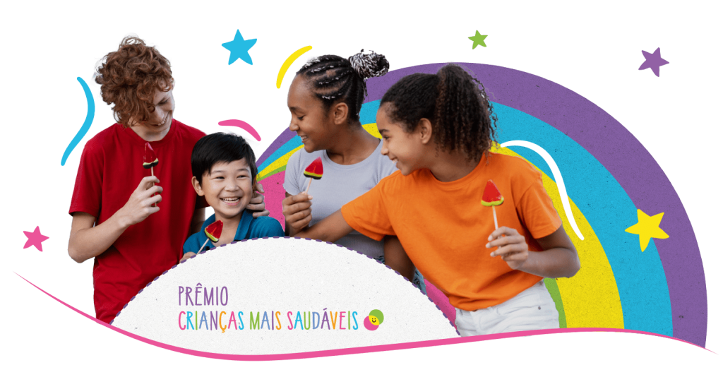 Quatro crianças, dois meninos e duas meninas, se divertem com fatias de melancia no palito. Um fundo colorido com estrelas, arcos e o texto "Prêmio Crianças Mais Saudáveis" está visível.